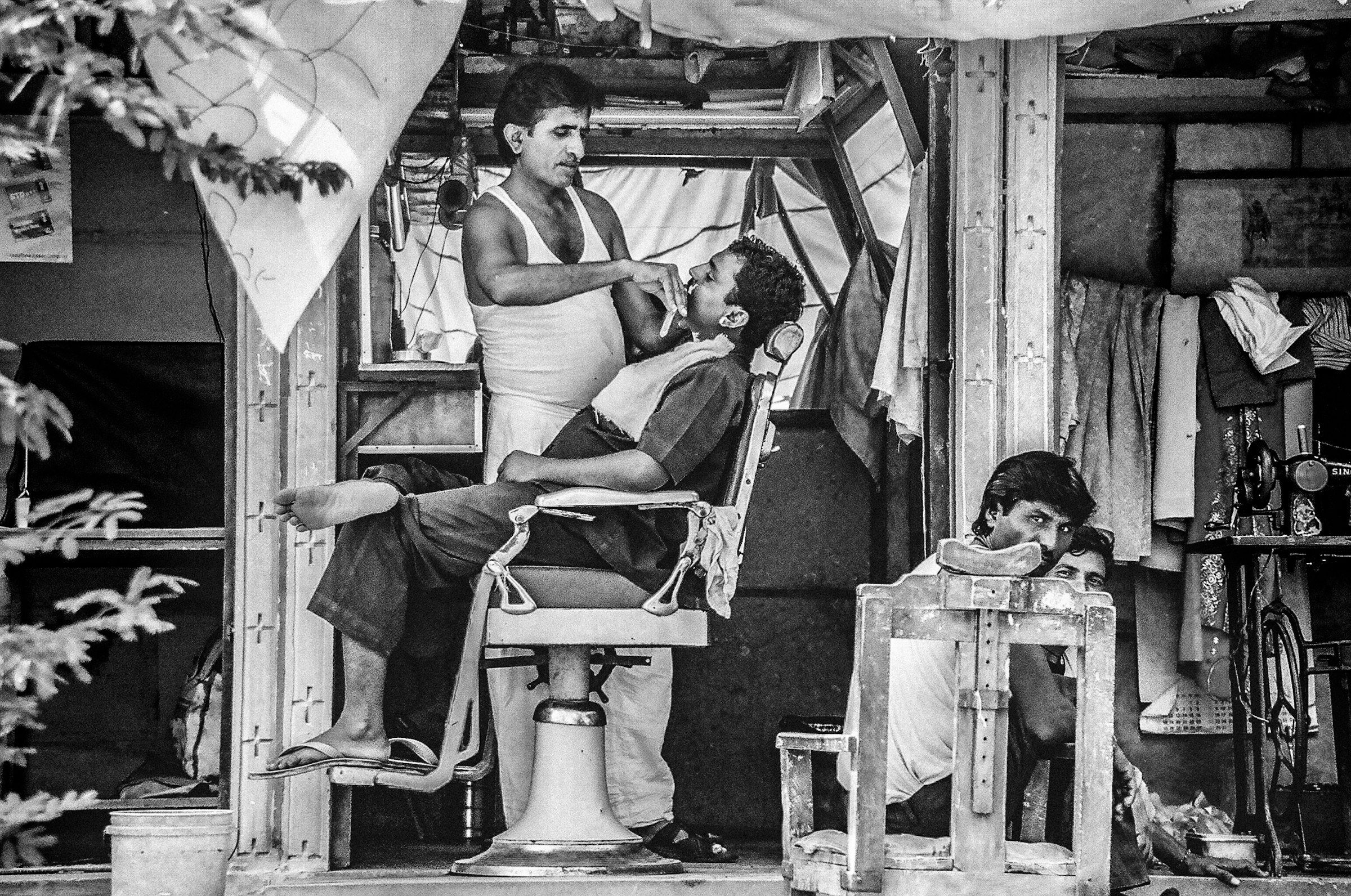 Close-up, black-and-white photo of a barber trimming a client's beard, representative of the beard work at Classic Chair Barbershop in Newmarket