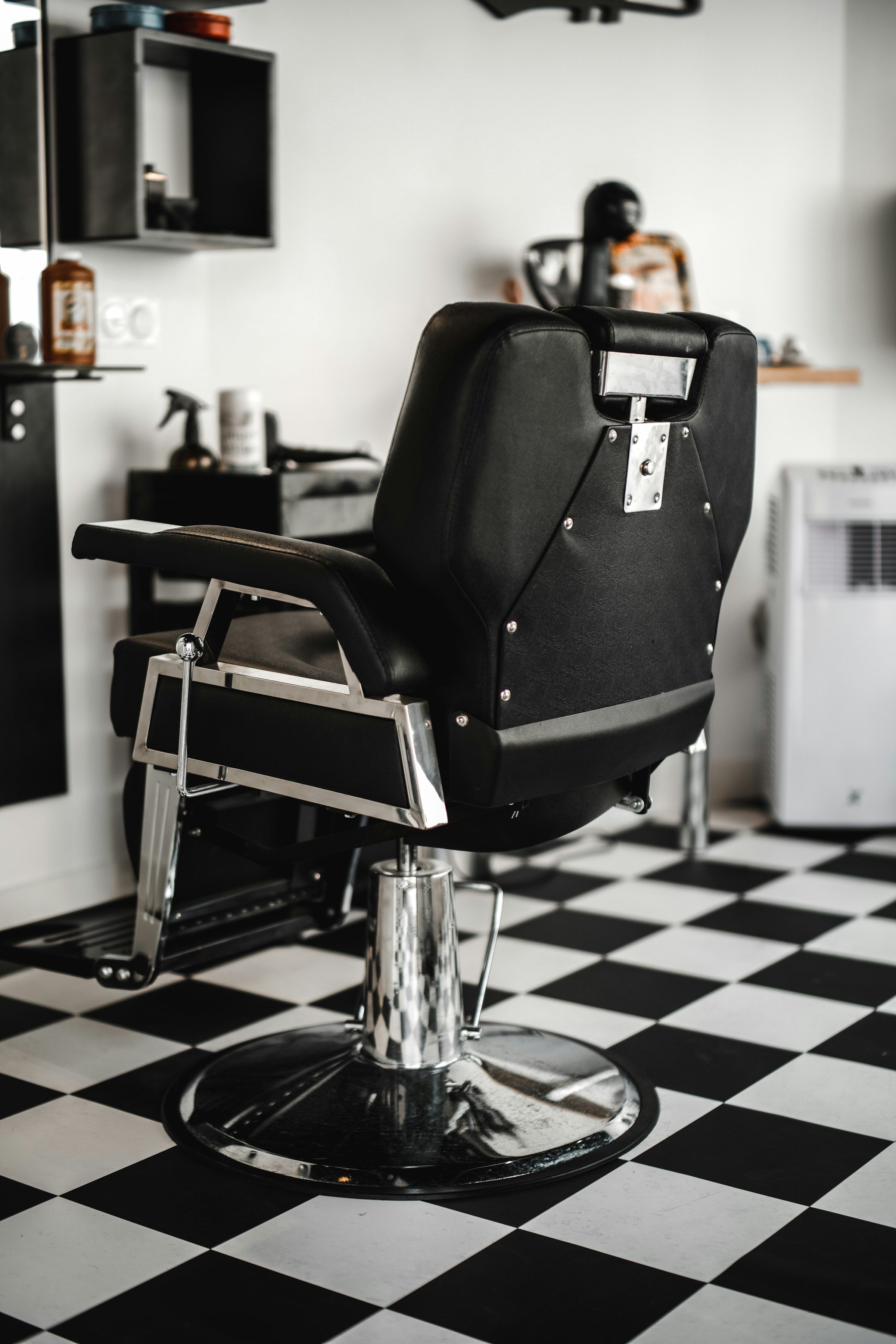 Black leather barber chair in a bright room, representative of the seating at Classic Chair Barbershop in Newmarket