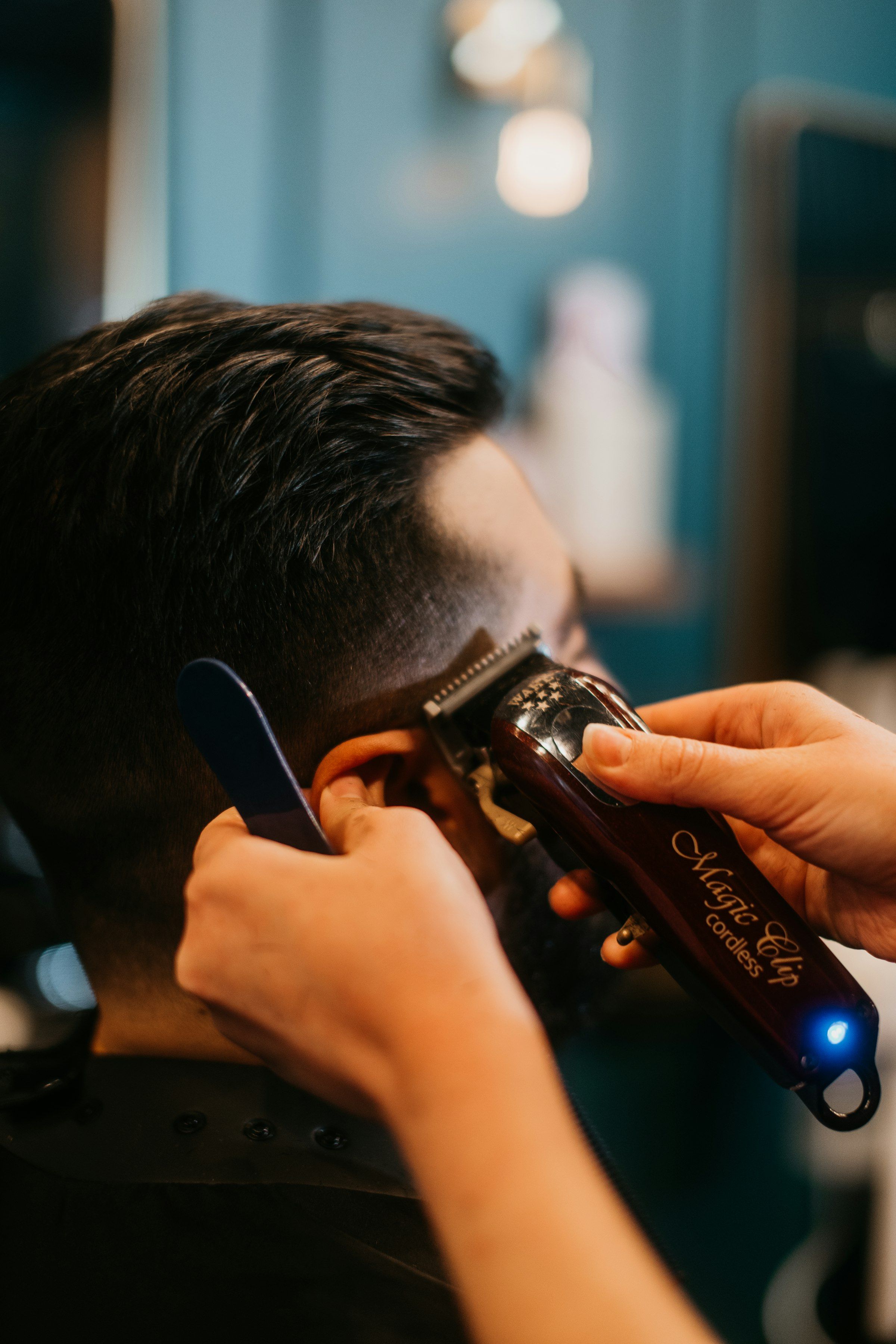 Barber cutting a client's hair with scissors, representative of the men's haircuts at Classic Chair Barbershop in Newmarket
